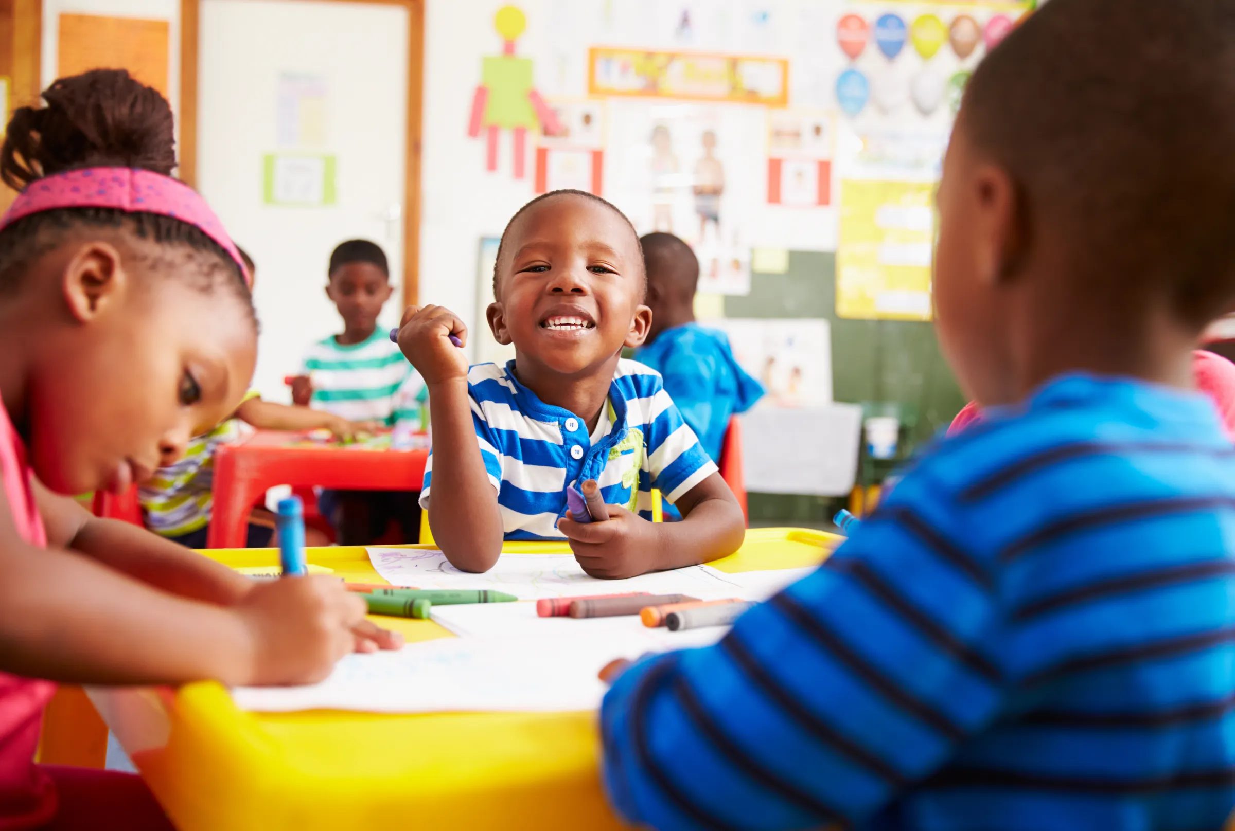 Preschool children coloring together at a classroom table